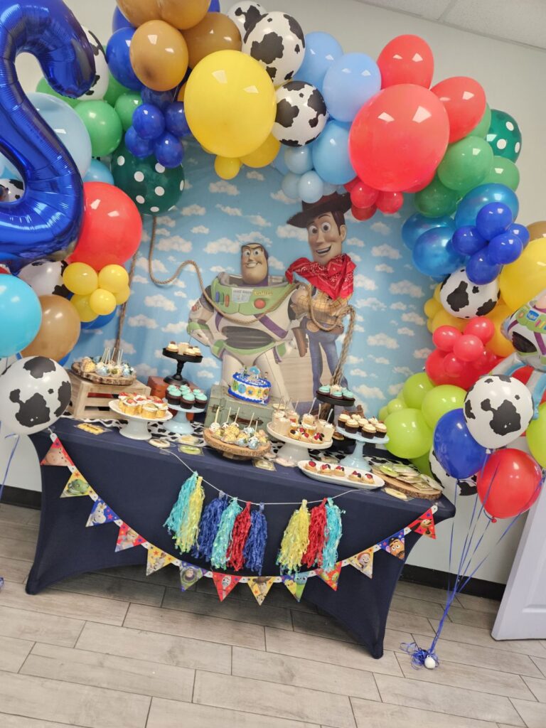 Beautifully decorated birthday party venue with play space and seating for kids and parents. Colorful 1st birthday party setup at kids event venue with decorations and play area